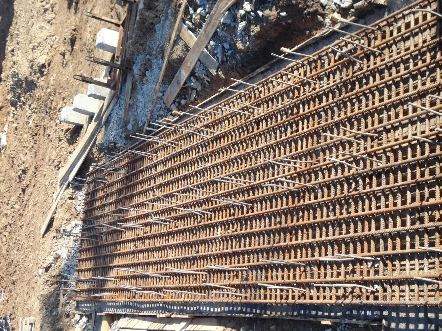 Residential site: reinforcement prepared along the excavation edge. Construction-report photograph, 2012.