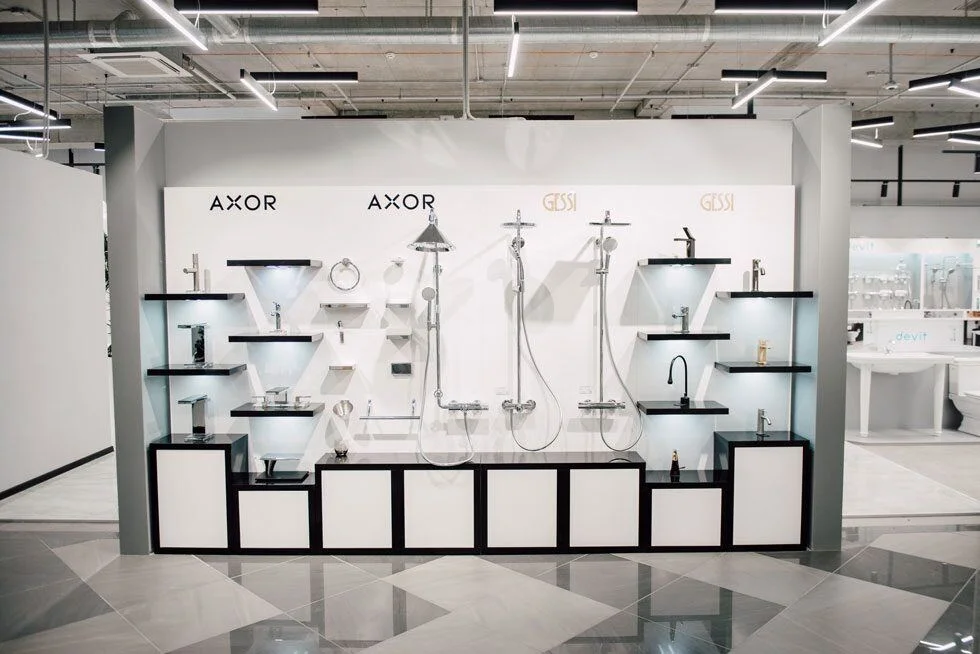 Agromat showroom: tap and shower displays with glazed office partitions behind. Retained project photograph.