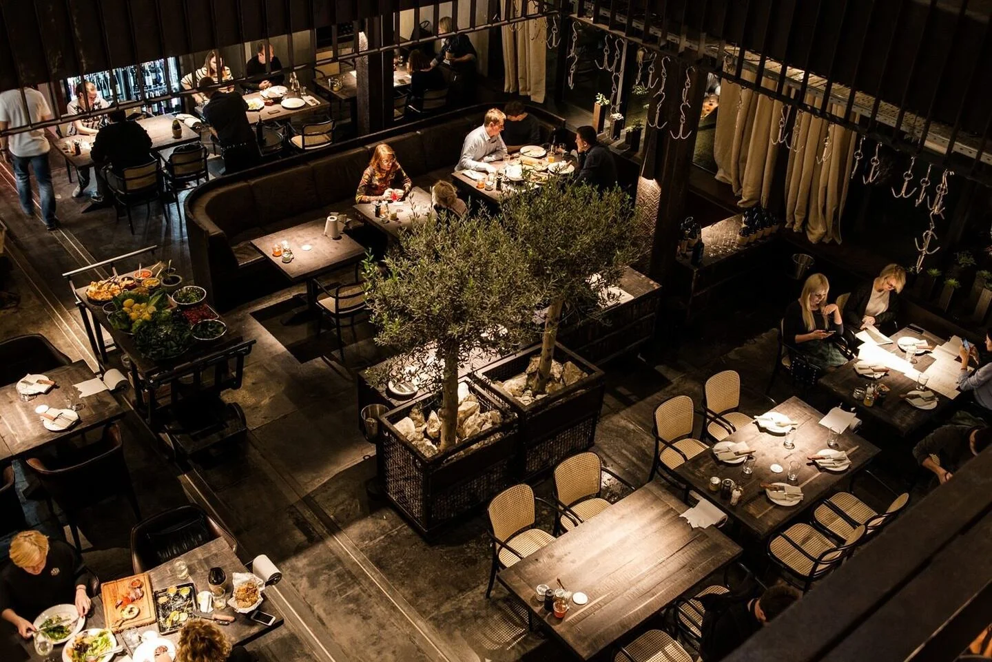 Steakhouse Kyiv: dining tables, seating and planting viewed from above. Project photograph; interior design by the appointed team.