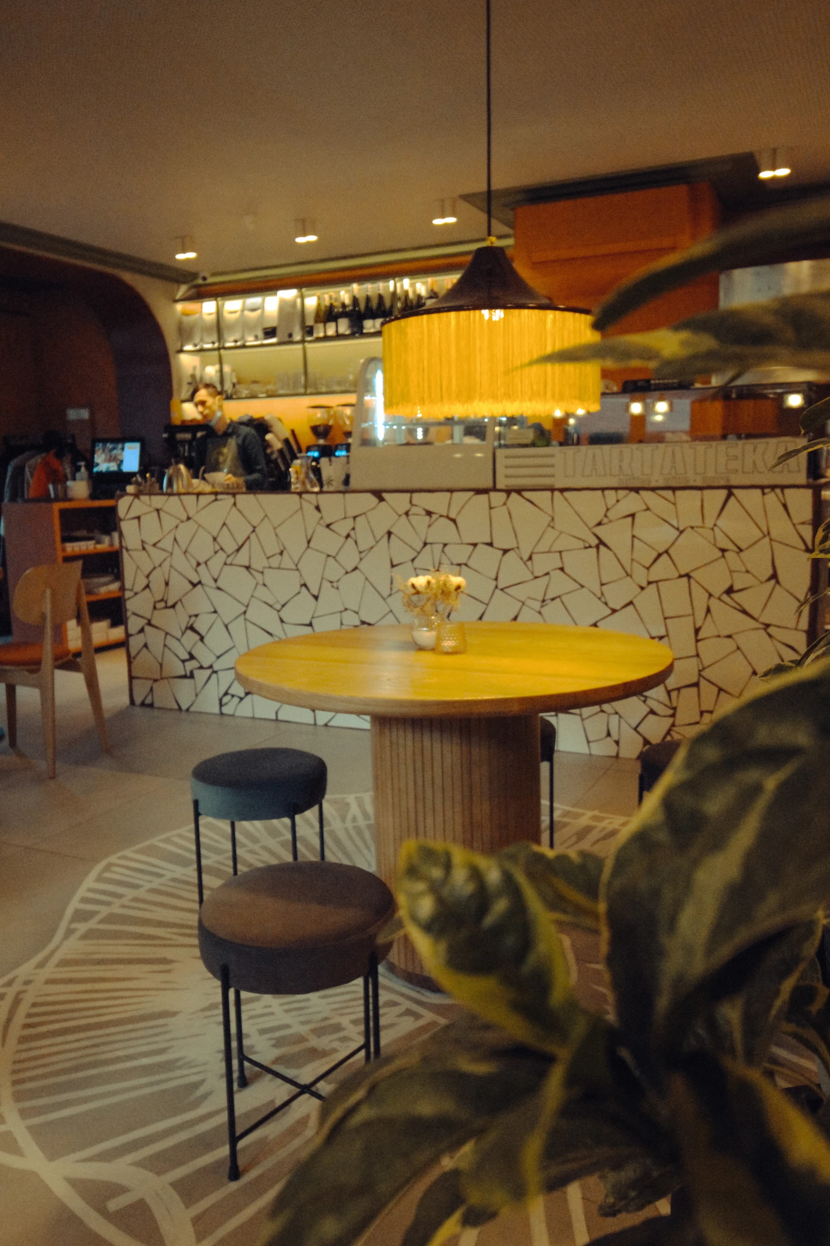 Tartateka: the tiled bar counter and tall stools. Completed-interior photograph.