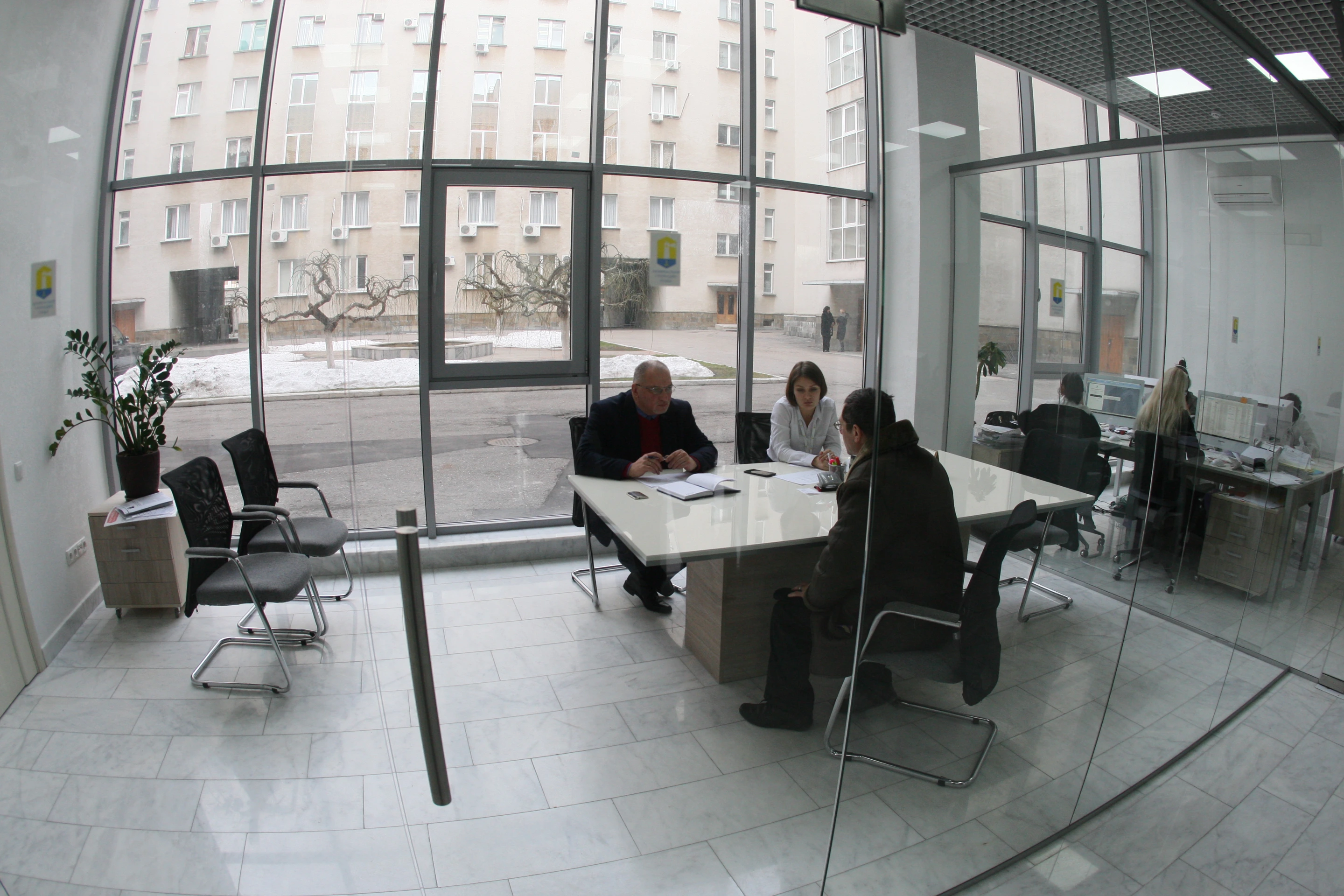 Public reception office — glass partitions and the street-facing interior. Retained photograph, 2018.