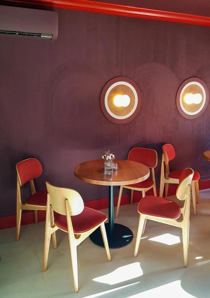Tartateka — a compact table beneath circular wall lights, March 2021.